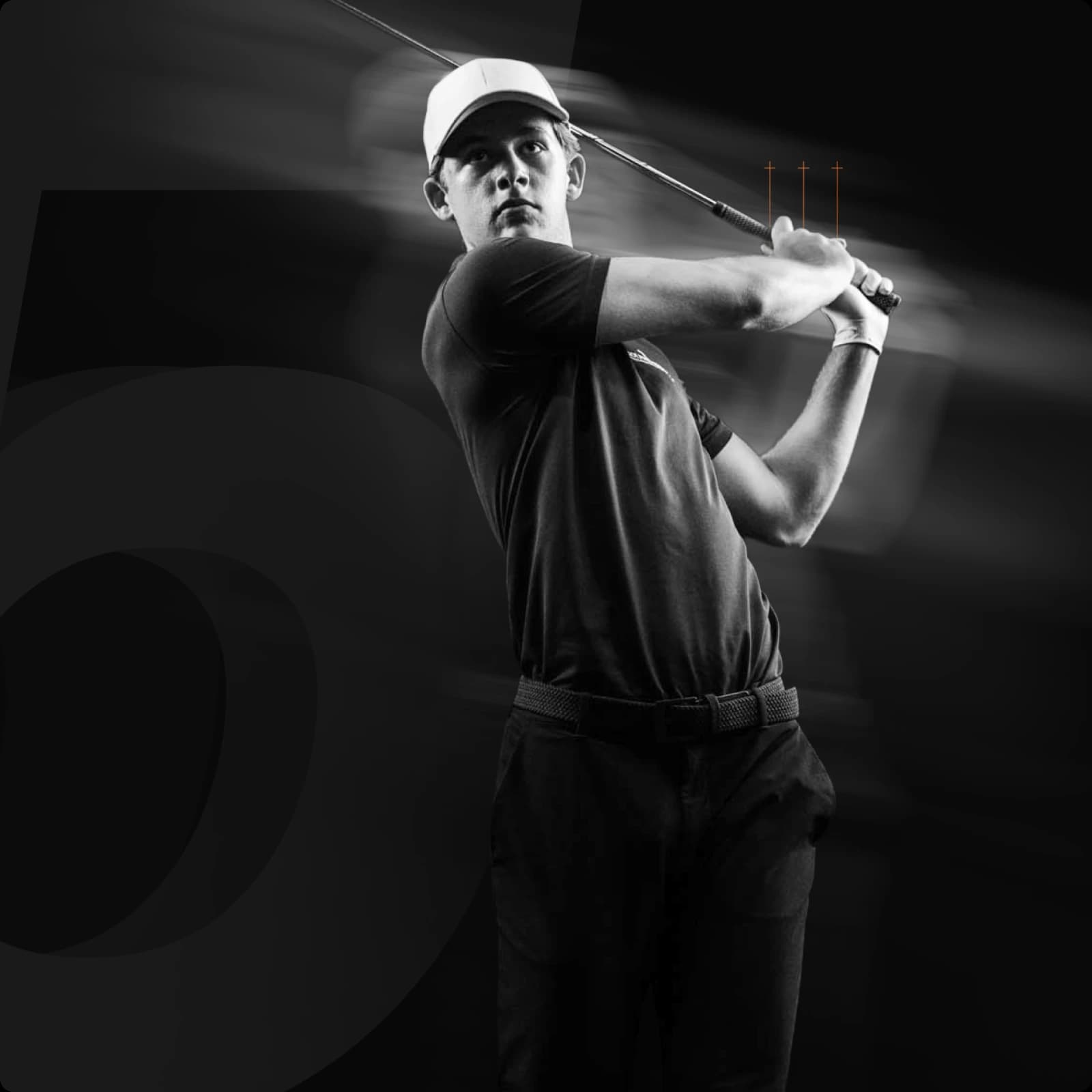 A golfer in a cap and dark attire is captured mid-swing in a black and white image, with motion blur emphasizing the dynamic action.
