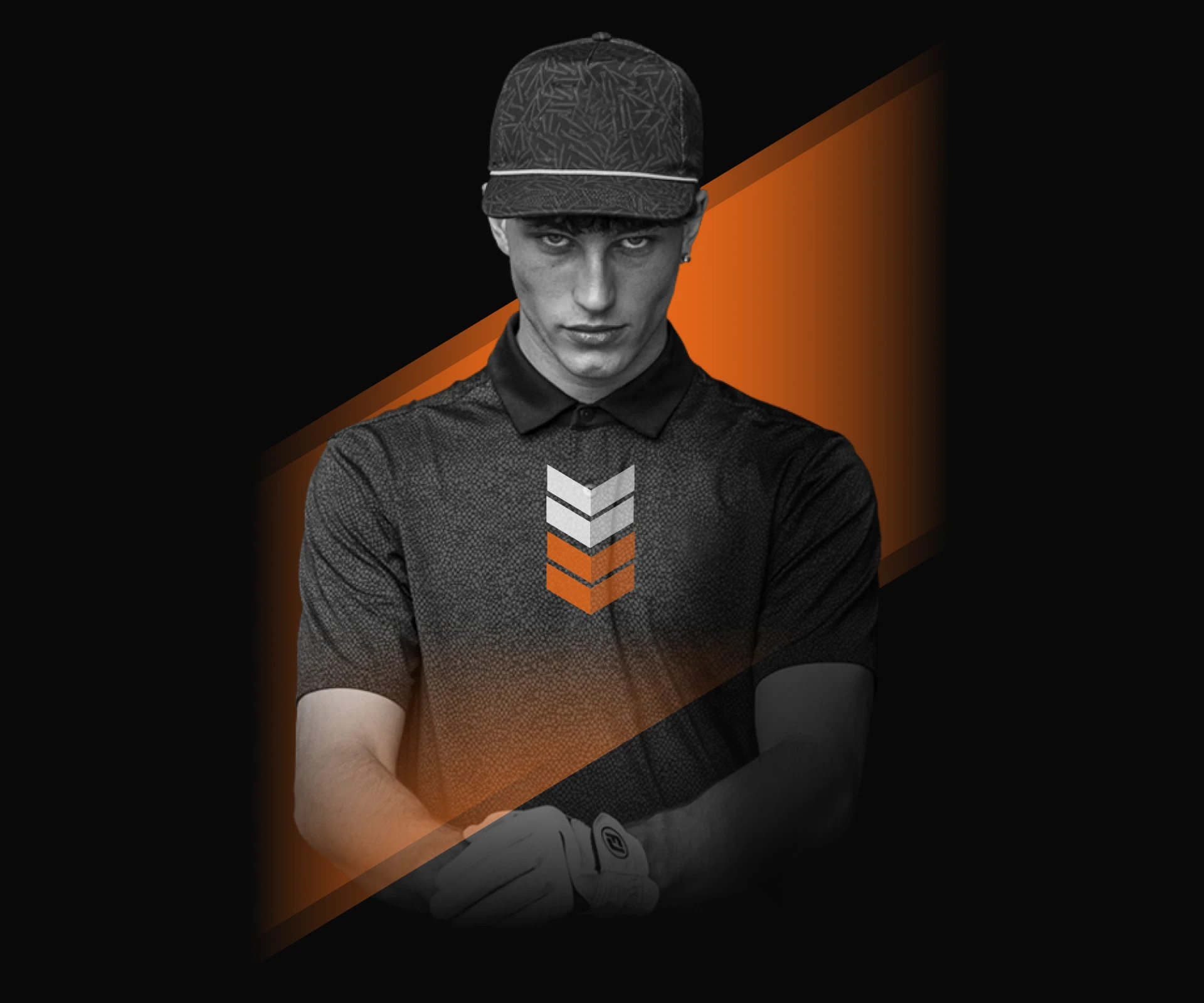 Man in a dark polo and cap with orange and white chevrons, holding a golf club, set against a black and orange background.